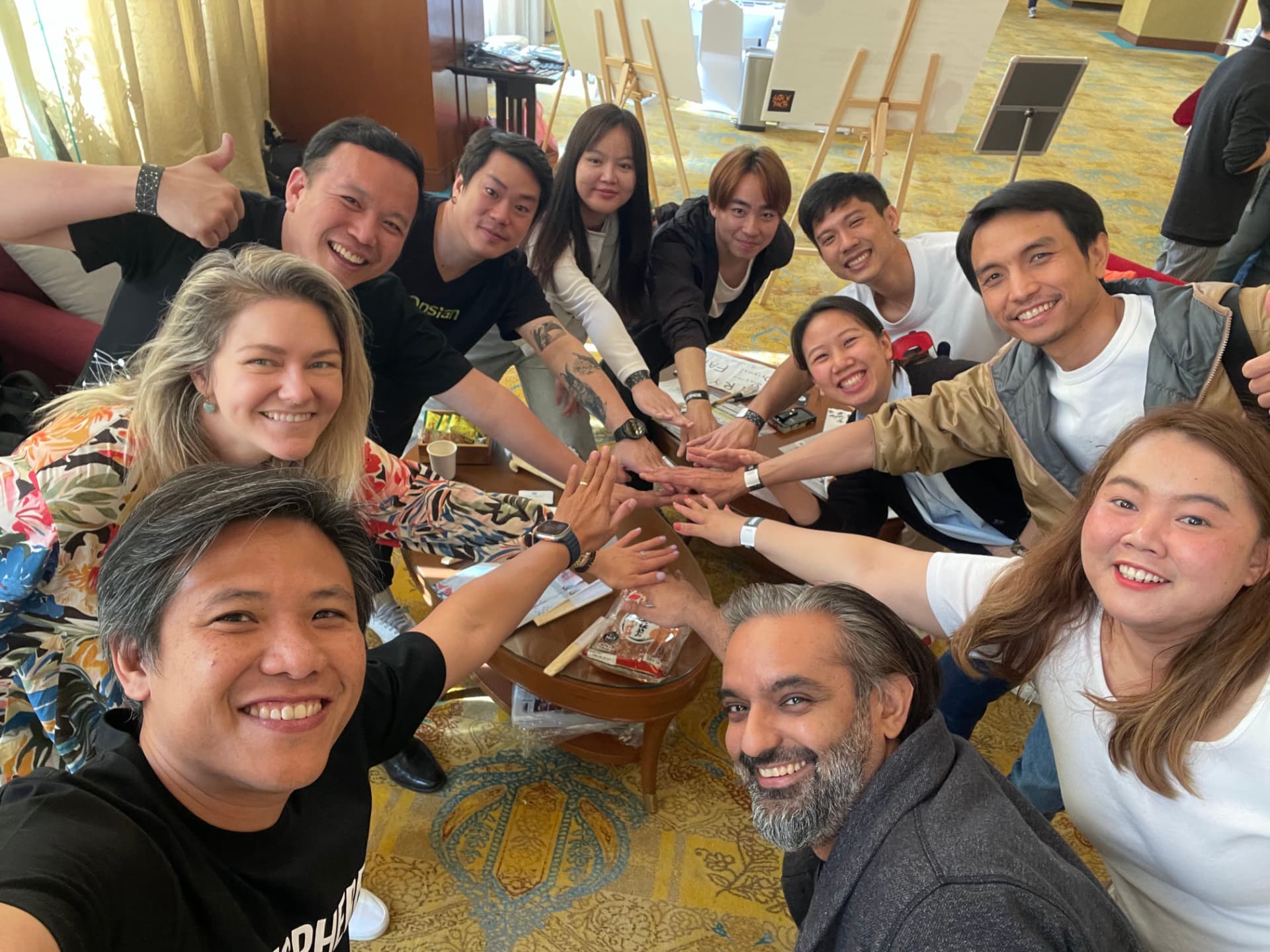 Hands working together over a table at an earlier Chiang Mai build session